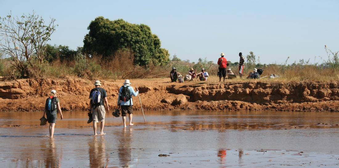 Shoes off on a river crossing, hiking in Madagascar |  <i>Janet Oldham</i>