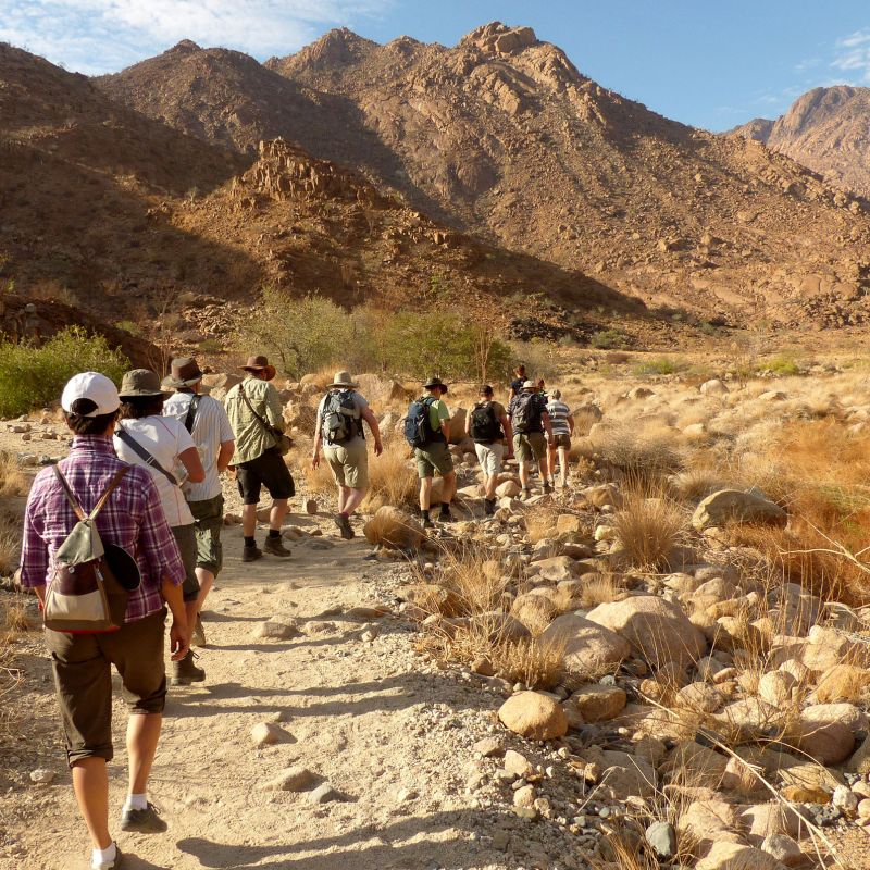 Brandberg Mountain walking through a rocky desert valley, Namibia