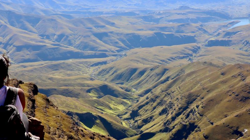 Drakensberg walker overlooking a vast valley and winding river, South Africa - Drakensberg Walking Tour, South Africa