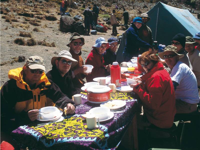 Camping beneath the snow capped peak of Kilimanjaro | Chris Buykx