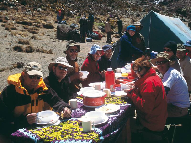Camping beneath the snow capped peak of Kilimanjaro | Chris Buykx