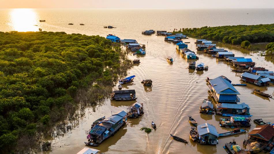 The sun setting over Mechrey floating village, Cambodia | Lachlan Gardiner