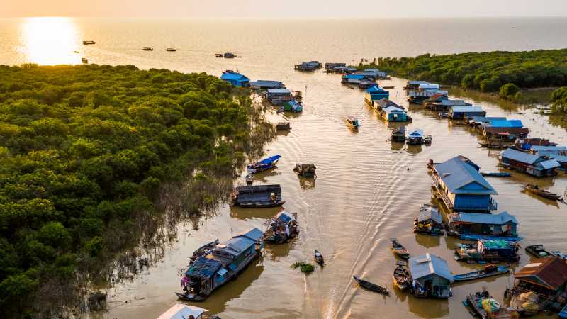 The sun setting over Mechrey floating village, Cambodia | Lachlan Gardiner
