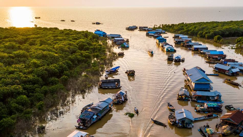 The sun setting over Mechrey floating village, Cambodia | Lachlan Gardiner
