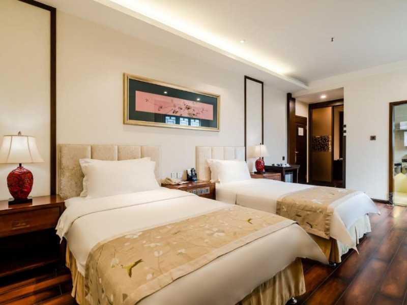 Elegant twin room at Buddha Zen Hotel, Chengdu: Featuring modern comforts with traditional decor, warm wooden floors, and a spacious ensuite bathroom.