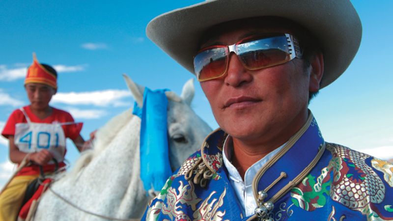 Locals enjoy dressing up in traditional 'deel' during Naadam celebrations - Tavan Bogd Trek Naadam Extension, Mongolia