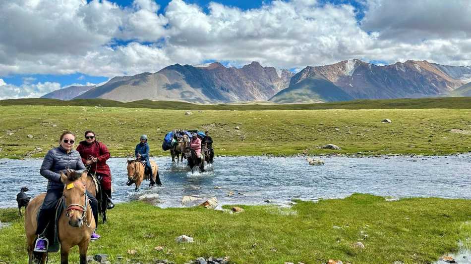 Feet up, smiles out. Crossing chilly rivers is part of the ride