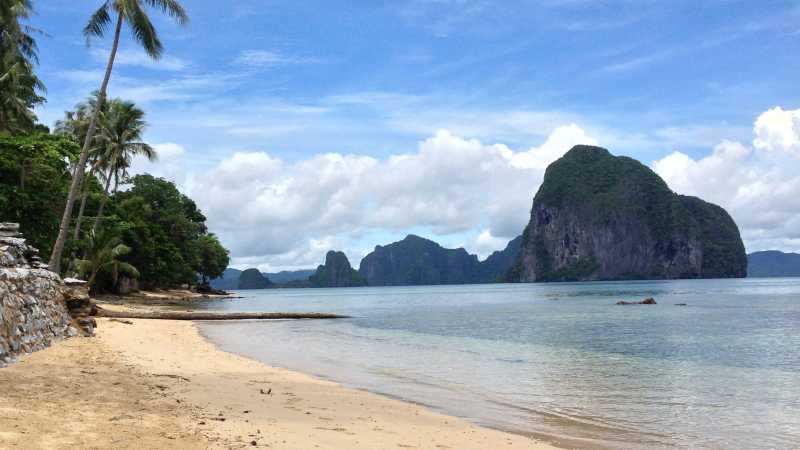 A peaceful cove bordered by forested limestone hills showcases the raw natural beauty of Palawan’s coastline. - A Culinary Expedition Through the Philippines with Chef Matthew Astorga, Philippines