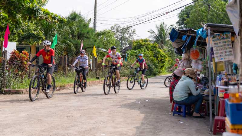 Cycling along a quiet village path through rural Vietnam,