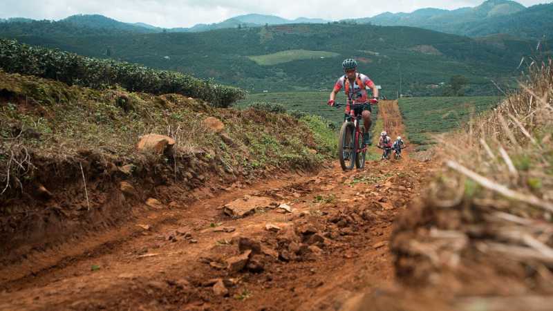 Cycling along a rural dirt track in Vietnam, passing rice fields and quiet village landscapes