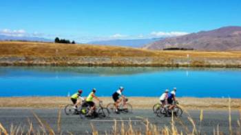 Cycling group enjoying views of the turquoise Hydro-Canals near Twizel.