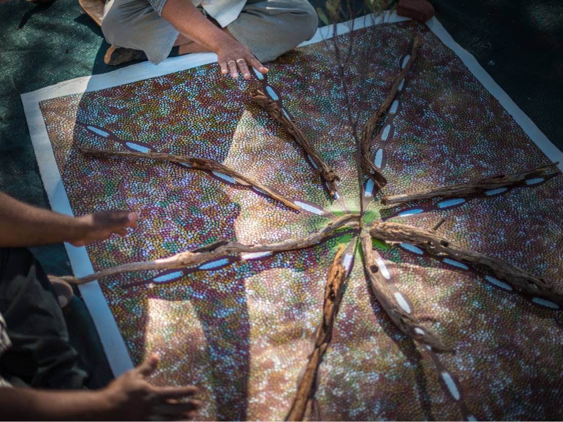 A tour guide uses a dot painting to talk about Aboriginal culture |  <i>Tourism NT/Matt Glastonbury</i>