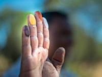 An Indigenous guide shows black, yellow, orange and white ochres during a cultural tour experience |  <i>Tourism NT/Matt Glastonbury</i>