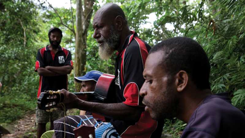 Kokoda support crew sharing music during a rest stop on the Kokoda Track | Ryan Stuart
