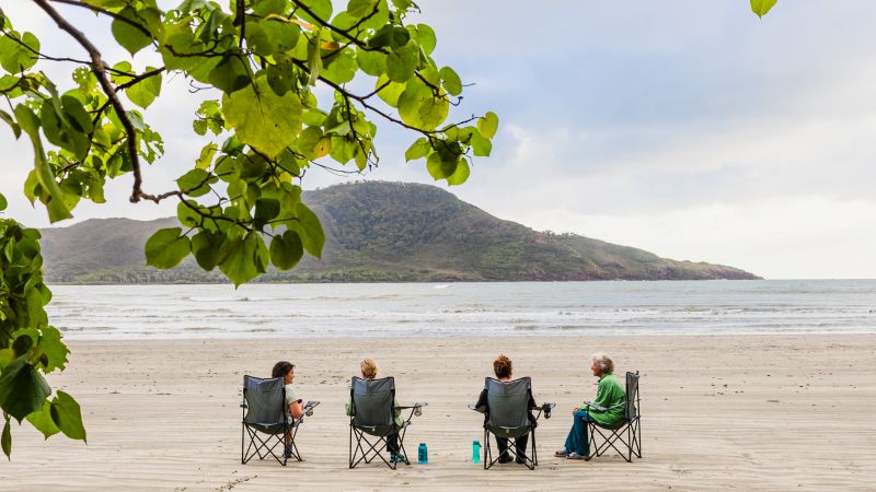 Thorsborne Trail trekkers rest on camp chairs along a quiet beach - Thorsborne Trail Guided Walk, Australia