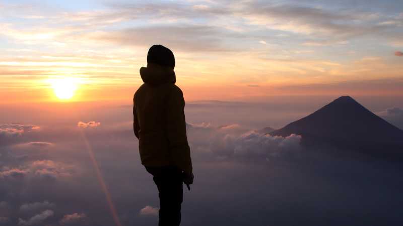 Hiker admiring the view from the summit of Volcan Acatenango