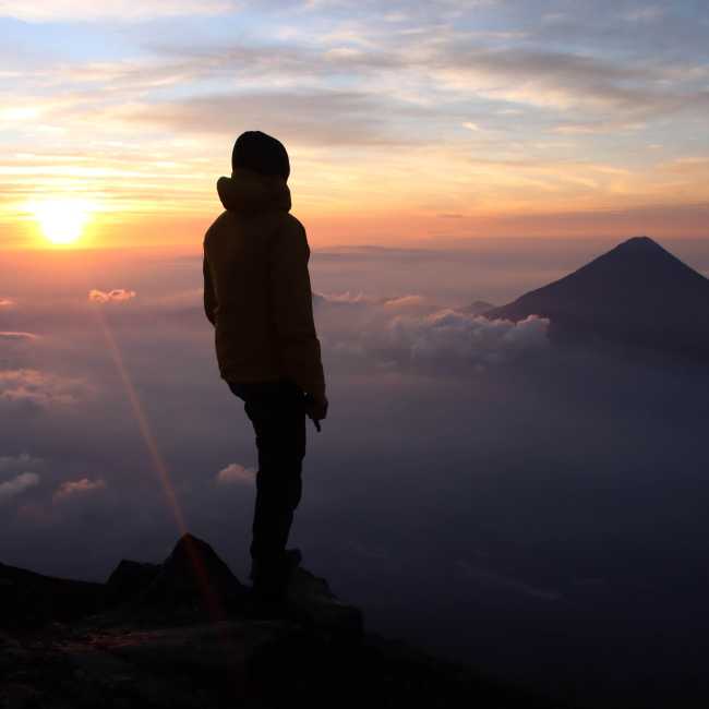 Hiker admiring the view from the summit of Volcan Acatenango