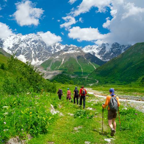 Trekkers enjoying the expansive mountain scenery in Georgia.