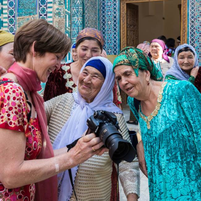 Pilgrims with traveller at Shah-i-Zinda, avenue of mausoleums, Samarkand | Richard I'Anson
