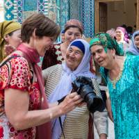 Pilgrims with traveller at Shah-i-Zinda, avenue of mausoleums, Samarkand | Richard I'Anson