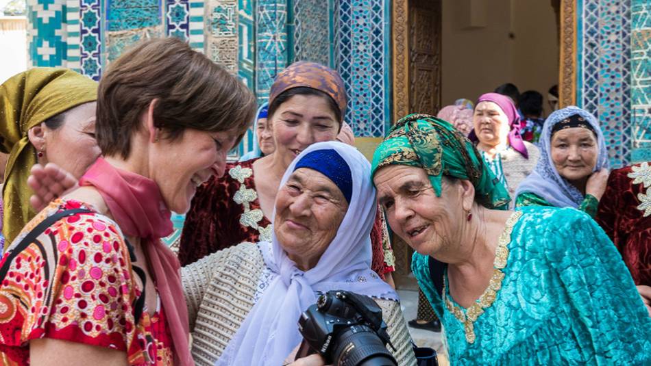 Pilgrims with traveller at Shah-i-Zinda, avenue of mausoleums, Samarkand | Richard I'Anson