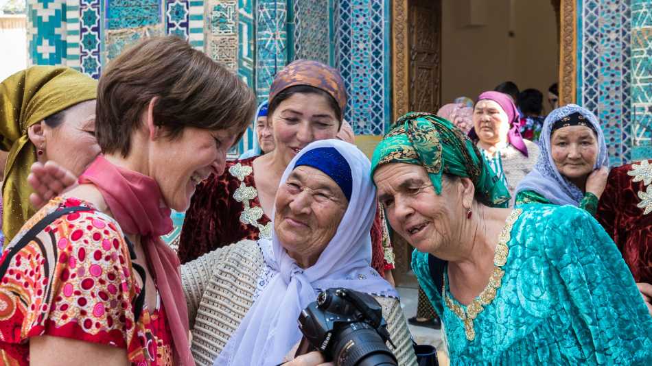 Pilgrims with traveller at Shah-i-Zinda, avenue of mausoleums, Samarkand | Richard I'Anson