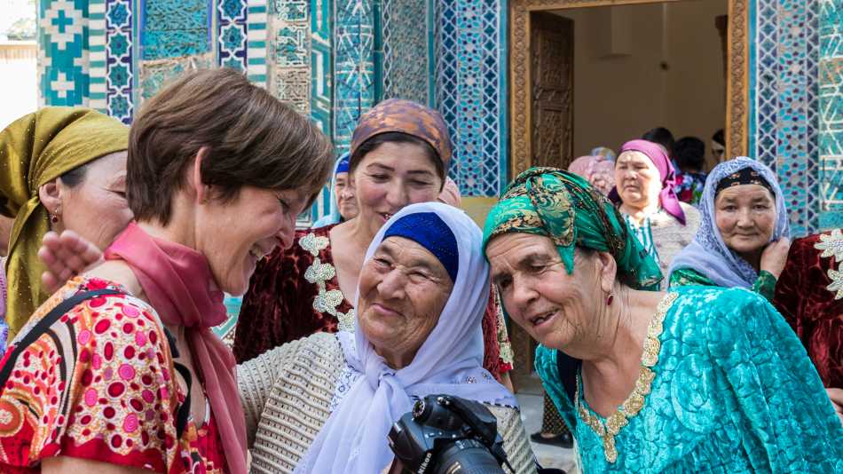 Pilgrims with traveller at Shah-i-Zinda, avenue of mausoleums, Samarkand | Richard I'Anson