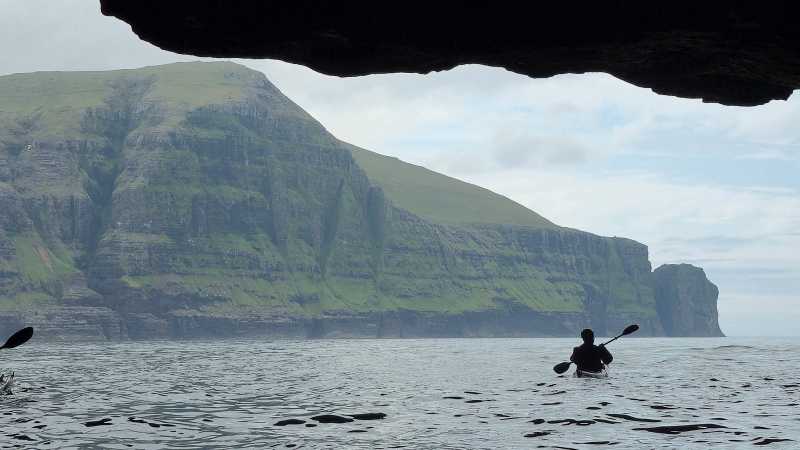 Sea kayaking from a coastal cave beneath the towering cliffs of the Faroe Islands - Faroe Islands: Kayaking the North Atlantic, Faroe Islands