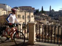 Cyclist viewing the historic cave dwellings in the Sassi di Matera |  <i>Kate Baker</i>