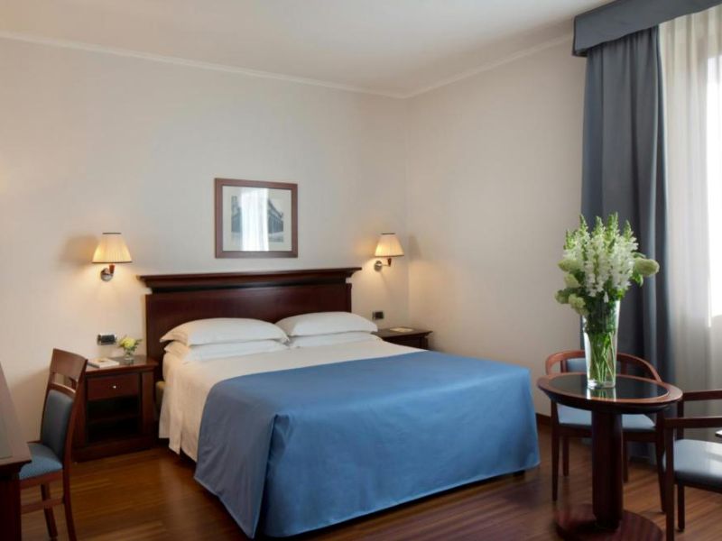 Double room at the Stars Hotel, Bologna, with twin bedside lamps and armchair