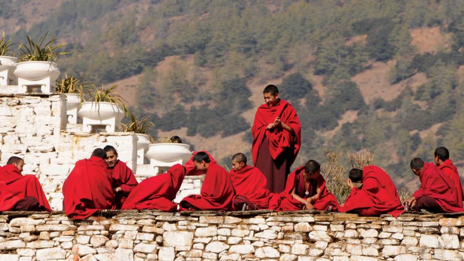 Bhutanese monks socialise along the monastery wall | Liz Light