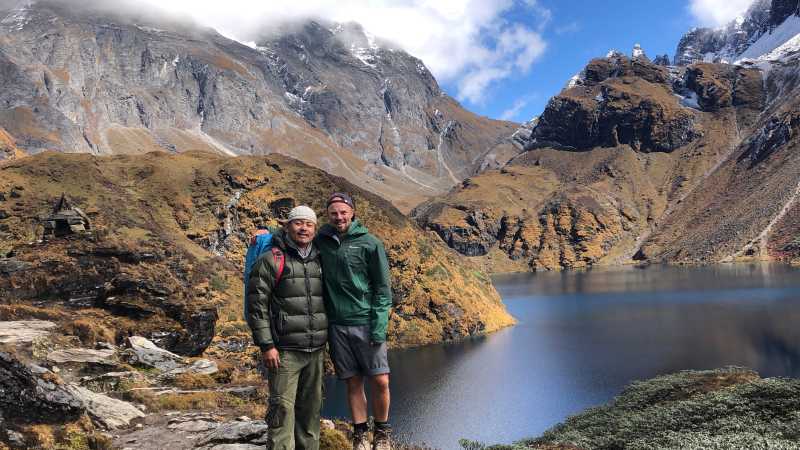 A trekker and guide pose in front of lake Om Tsho on the Bhutan Snowman Trek | Matt Brazier