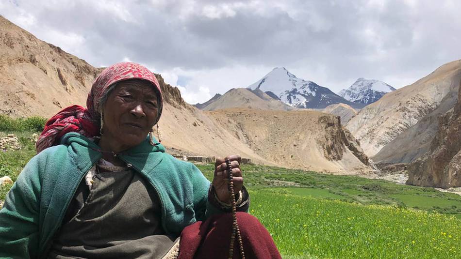 Markha valley villager tending her field with Kangyaze (6400m) in the background | Brad Atwal