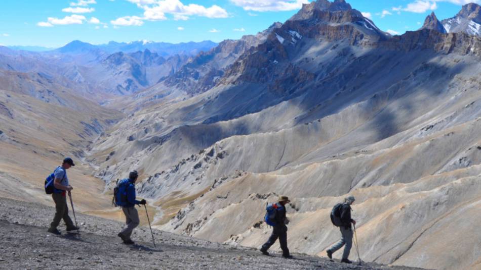 Trekkers making their way across the vast and awe-inspiring landscape of the Zalung La pass, framed by the majestic peaks of Ladakh. | Garry Weare