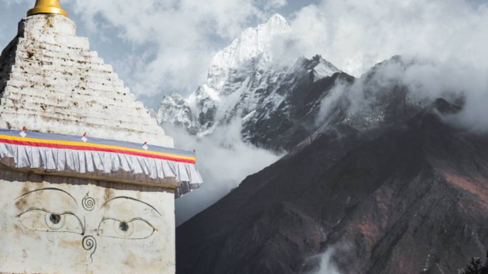 Buddhist Stupa beneath towering mountains | Kelvin Law