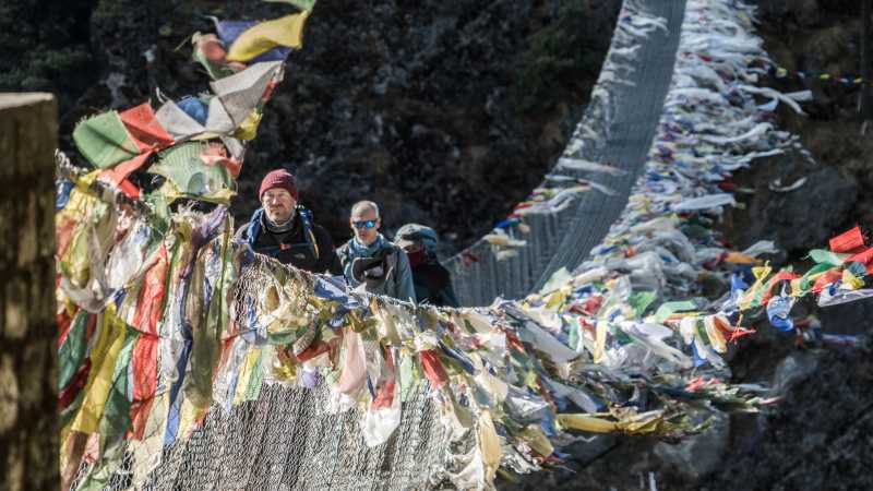 Cross deep ravines on suspension bridges fluttering with prayer flags | Dan Cassar