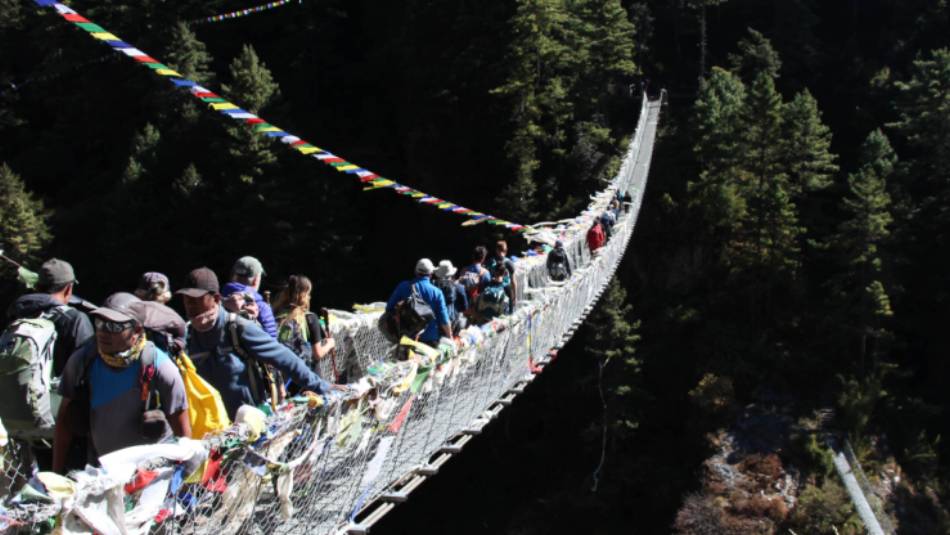 Prayer flags flying on a bridge crossing in the Everest Region | Ayla Rowe