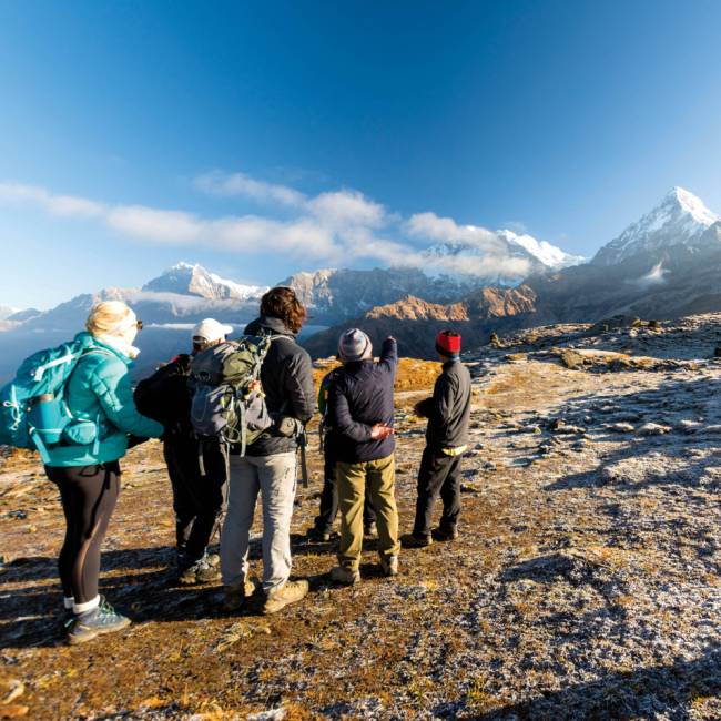 A World Expeditions porter looks on as the group enjoys the view on Kopra Ridge | Joe Kennedy