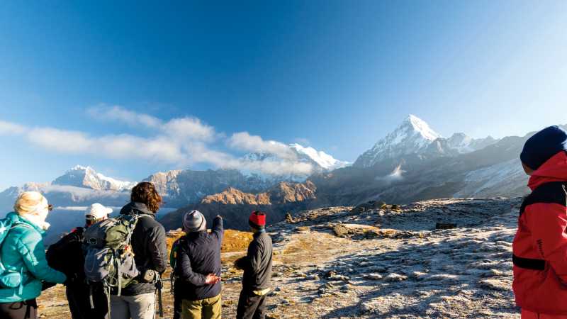 A World Expeditions porter looks on as the group enjoys the view on Kopra Ridge | Joe Kennedy