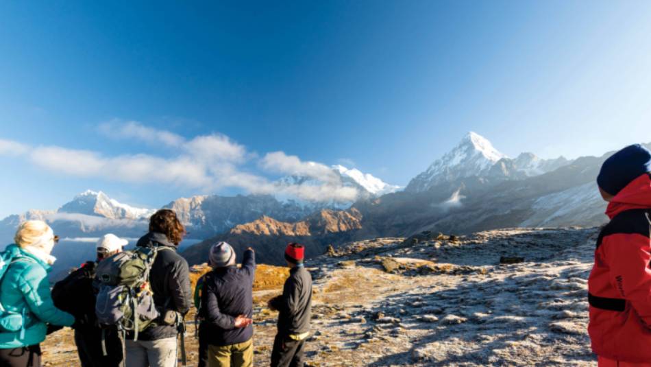 A World Expeditions porter looks on as the group enjoys the view on Kopra Ridge | Joe Kennedy