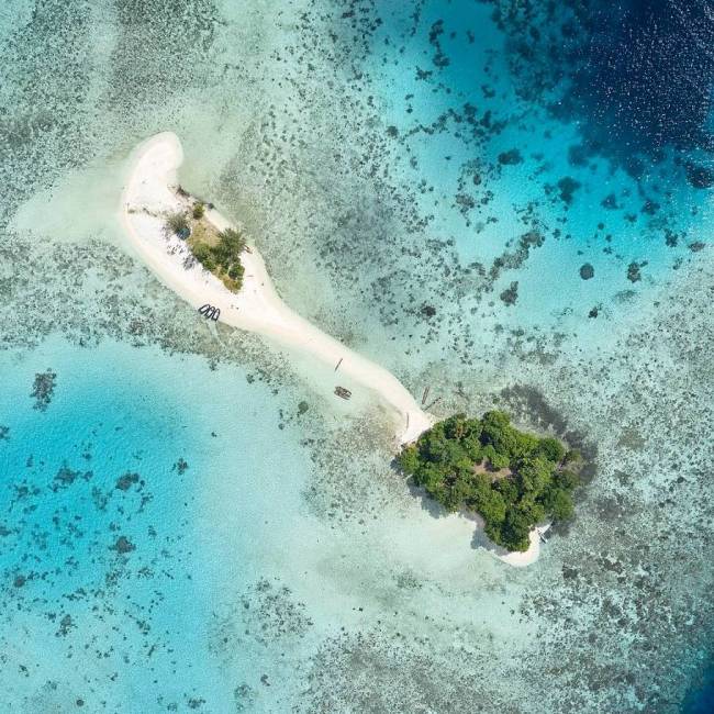 Aerial shot of an uninhabited island in the western pacific | E Bell