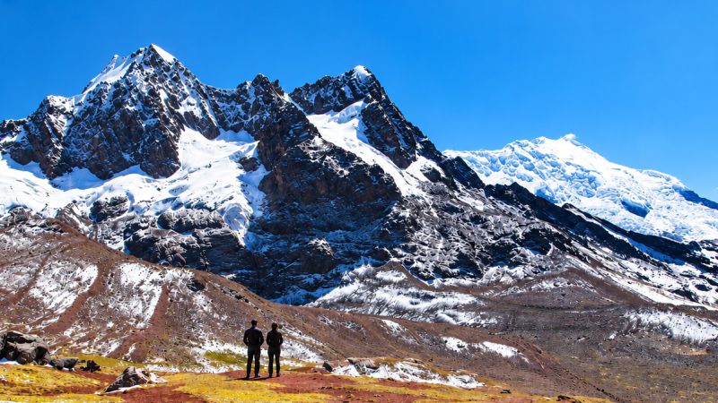 Ausangate Trek trekkers pause before snow-capped peaks in the Peruvian Andes - Ausangate Trek, Peru
