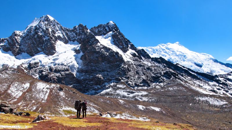 Ausangate Trek trekkers pause before snow-capped peaks in the Peruvian Andes - Ausangate Trek, Peru