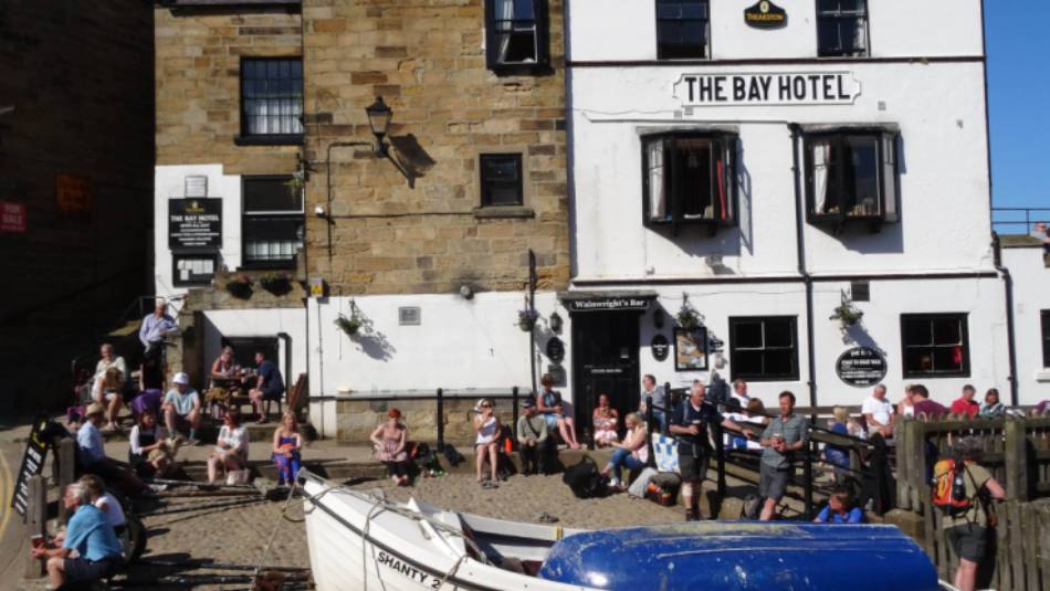 Walkers celebrating the end of the Coast to Coast in Robin Hood's Bay | John Millen