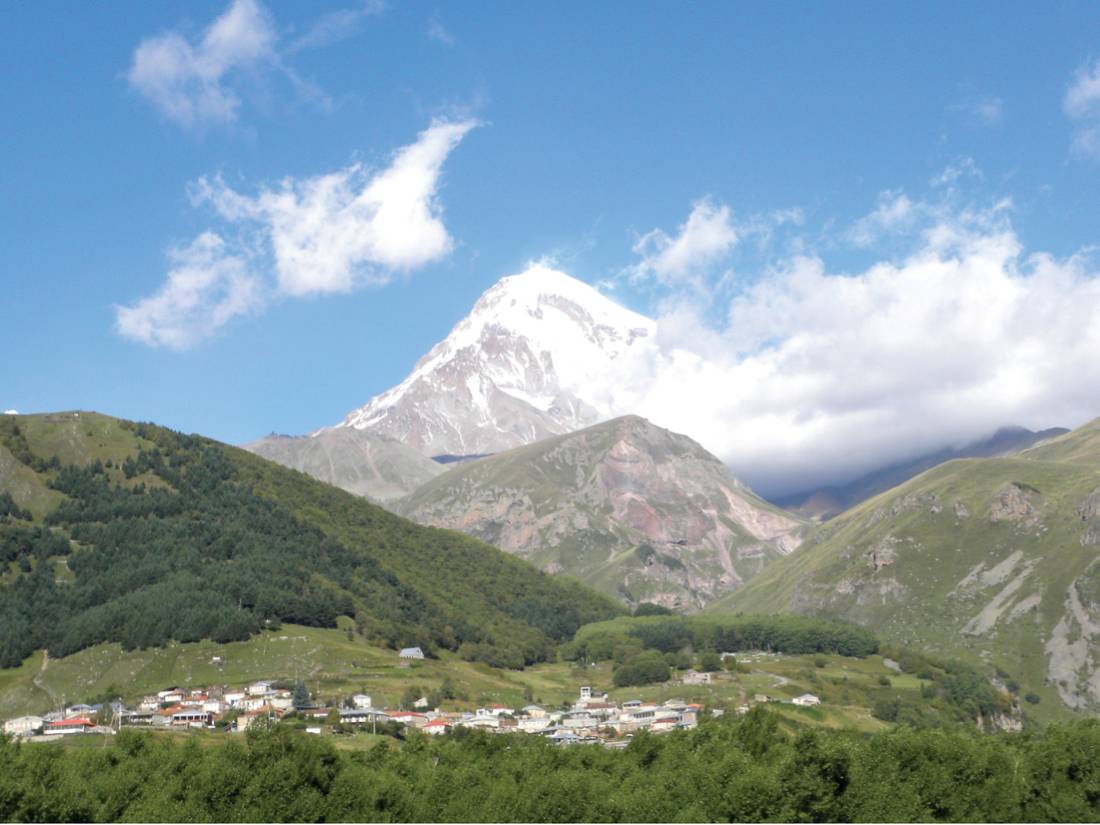 Views over the Georgian town of Kazbegi to Mt Kazbek in Caucasus region