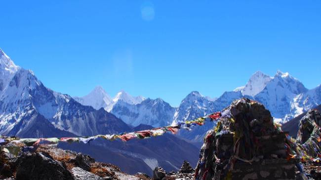 Memorial rock cairns and prayer flags on the way to Lobuche