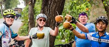 Cyclists enjoying a cool coconut in the streets of Ho Chi Minh | Lachlan Gardiner