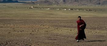 Local Tibetan monk enjoying the open fields and the warm sunlight | Gavin Turner